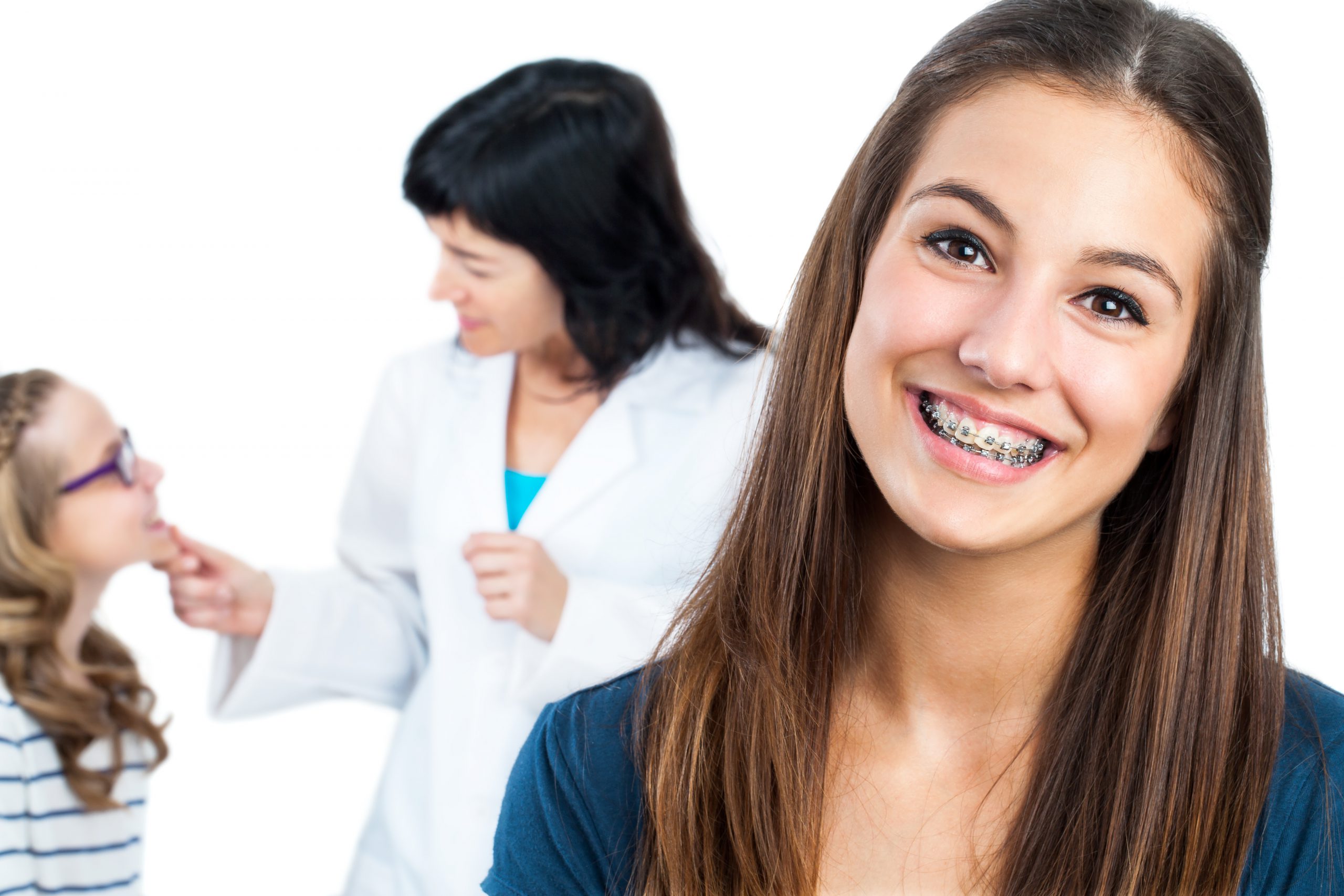 Teen girl with braces and doctor with patient in background.